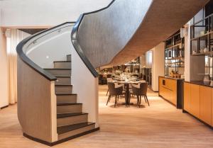 a staircase leading up to a dining room with a table at Centennial Nexus Hotel Tallinn in Tallinn