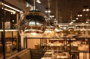 a restaurant with a wine glass hanging from the ceiling at Centennial Nexus Hotel Tallinn in Tallinn