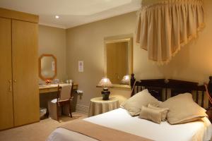 Säng eller sängar i ett rum på Le Chateau Guest House and Conference Centre