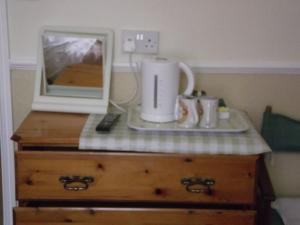 een magnetron bovenop een houten dressoir bij beaufort guesthouse in Weymouth