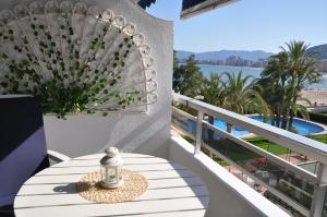 a table on a balcony with a view of the water at Palm Tree Cullera in Cullera
