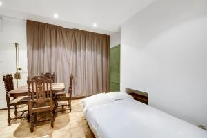 a bedroom with a bed and a table and chairs at Louvre Tuileries ID257 in Paris