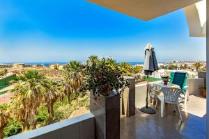 a balcony with a table and an umbrella and the ocean at Atalaya court in Adeje