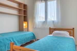 sypialnia z 2 łóżkami i oknem w obiekcie Villa Thea w mieście Ajos Nikolaos