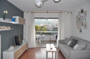 a living room with a couch and a tv and a table at Palm Tree Cullera in Cullera