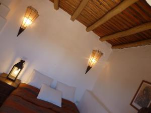 een slaapkamer met een bed en twee lampen aan de muur bij Riad Cascades d'Ouzoud in Ouzoud