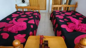 2 Betten in einem Zimmer mit rosa Herzen in der Unterkunft Stunning La Mata Beach Suite in La Mata + 19 Fotos