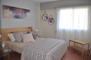 a bedroom with a large bed and a window at Palm Tree Cullera in Cullera
