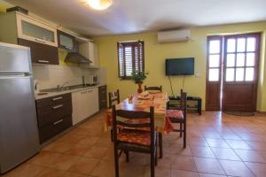 a kitchen with a table with chairs and a refrigerator at Apartments Villa Forida in Mali Lošinj