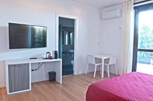 a bedroom with a desk with a tv and a table at Four Rooms Guesthouse in Oristano