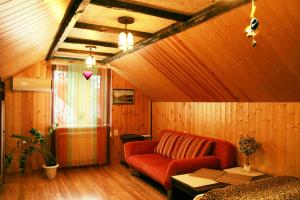 エッセントゥキにあるVacation Home on Andzhievskogoの赤いソファと木製の壁が備わるリビングルーム