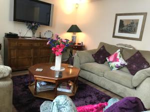 a living room with two couches and a table with flowers at City Centre Executive Apartment - Private Parking, Gym & Sauna in Aberdeen