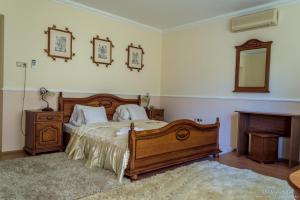 a bedroom with a wooden bed and a mirror at Parish Bull Hotel in Kisv&aacute;rda
