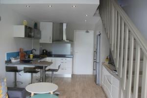 een keuken met witte kasten en een tafel bij Colibri des îles in Le Gosier