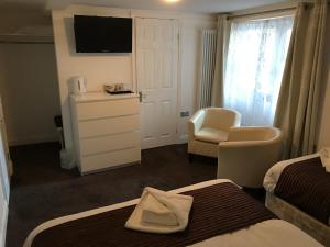 a hotel room with a bed, toilet and television at St George Hotel Great Yarmouth in Great Yarmouth
