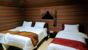 a bedroom with a bed and two lamps at Beyond Wadi Rum Camp in Wadi Rum