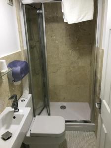 uma casa de banho com um chuveiro, um WC e um lavatório. em St George Hotel Great Yarmouth em Great Yarmouth