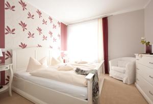 a bedroom with a white bed and a window at Boutiquehotel Das Haus am Walde in Bad Bevensen