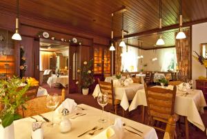 バート・ベヴェンセンにあるBoutiquehotel Das Haus am Waldeの白いテーブルと椅子、照明が備わるレストラン