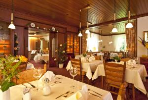 a restaurant with white tables and chairs and lights at Boutiquehotel Das Haus am Walde in Bad Bevensen