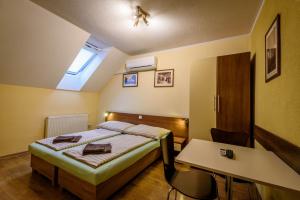 a bedroom with a bed and a desk and a table at Apartmany Hujer in Bojnice