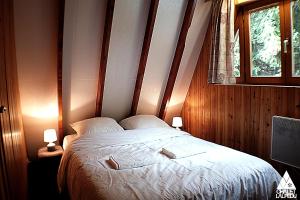 a bedroom with a bed with two pillows and a window at Chalet LALPEDU in L'Alpe-d'Huez