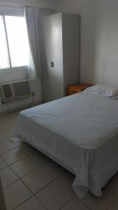 uma cama branca num quarto com uma janela em Apartamento Pontal Beach. no Rio de Janeiro