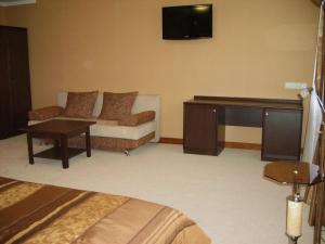 Habitación de hotel con sofá y escritorio en Hotel Complex Gayki en Zhytomyr