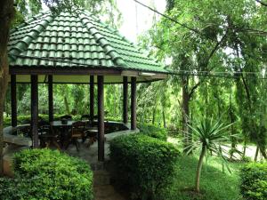 ฺBaan Ing Khao Resort في مواكليك: شرفة مع طاولة وكراسي في حديقة