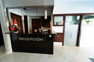 a woman sitting at a reception desk in an office at Visit Hotel in Caspe