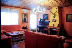 a living room with a couch and a piano at Hotel Rural Restaurante Los Rosales in Almadén