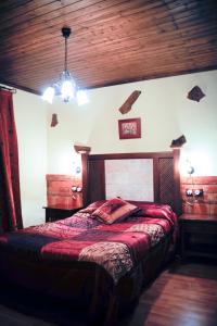 a bedroom with a bed and a wooden ceiling at Hotel Rural Restaurante Los Rosales in Almadén