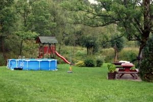 einen Park mit einem Spielplatz mit einer roten Rutsche und einem Tisch in der Unterkunft U Eskulapa in Lutowiska