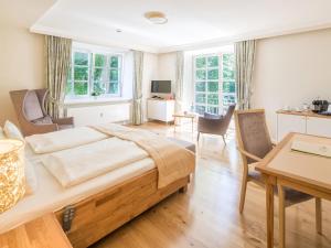 1 dormitorio con 1 cama grande y 1 mesa en Hotel Landhaus Ammann, en Hannover