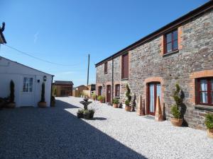 a courtyard of a brick building with potted plants at Langdon Farm Cottage in Boyton