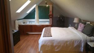 1 dormitorio con cama blanca y bañera en The Inn at Ragged Edge, en Chambersburg