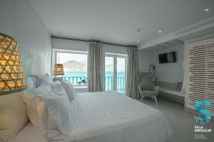 a bedroom with a white bed with a view of the ocean at Villa Singular in San José