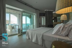 a bedroom with a large bed and a balcony at Villa Singular in San José