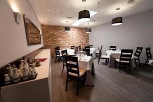 uma sala de jantar com mesas brancas e cadeiras pretas em Visit Hotel em Caspe