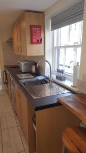 a kitchen with a sink and a counter top at 1 bed self catering apartment in Weymouth