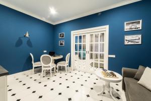 スヴェトロゴルスクにあるOld City Boutique Apartmentsの青い壁のリビングルーム(テーブル、椅子付)