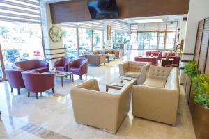 デニズリにあるGrand İtimat Hotelのソファ、テーブル、椅子が備わる待合室