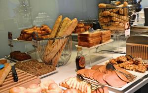 a display case with various types of bread and pastries at Mercure Toulouse Centre Saint-Georges in Toulouse