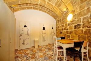 une salle à manger avec une table et deux mannequins sur le mur dans l'établissement Vallettastay Dormitory shared hostel, à La Valette