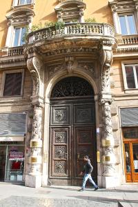 a man walking in front of a large wooden door at Xenia Guest House in Rome