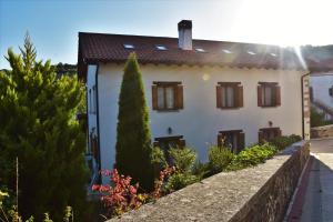 una casa blanca con una pared y árboles en Casa Artegia en Mezkiriz