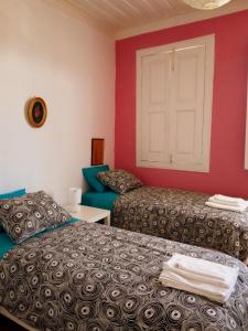 カベセイラス・デ・バストにあるCasa de Encosturasのベッド2台と白いドアが備わる客室です。