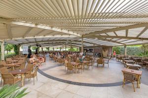 a patio with tables and chairs and people sitting at tables at Royal Holiday Palace in Lara