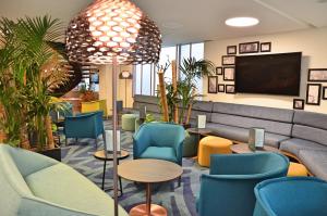 a waiting room with blue chairs and a couch at Mercure Toulouse Centre Saint-Georges in Toulouse