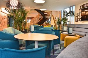 a restaurant with tables and chairs and a staircase at Mercure Toulouse Centre Saint-Georges in Toulouse